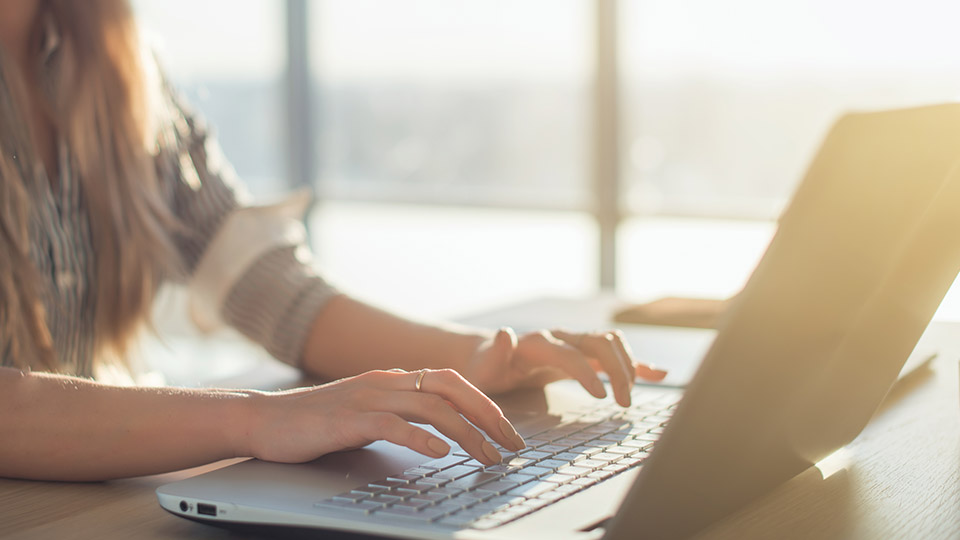 Ghostwriting: Frau, die gerade einen Text auf Ihrem Laptop tippt.