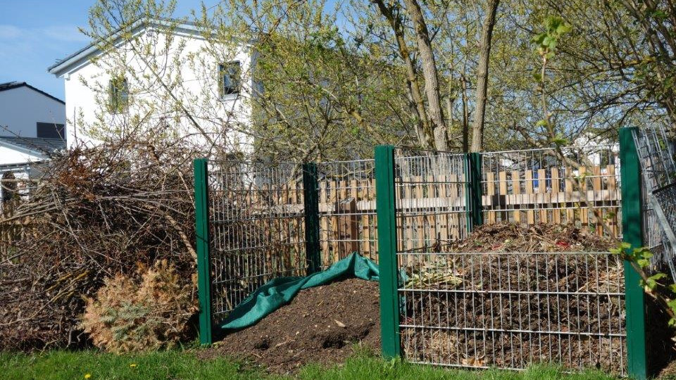 Kurs des Gartenamts Regensburg: Bild von einem Komposthaufen inmitten einer grünen Wiese