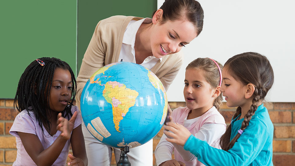 "Mehr Zeit für Kinder": Lehrerin, die sich mit Schülerinnen gemeinsam den Globus ansieht