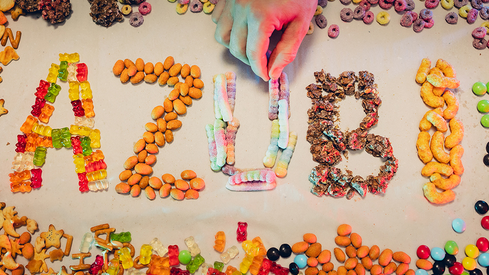 Das Wort "AZUBI", das gerade jemand aus Süßigkeiten legt.