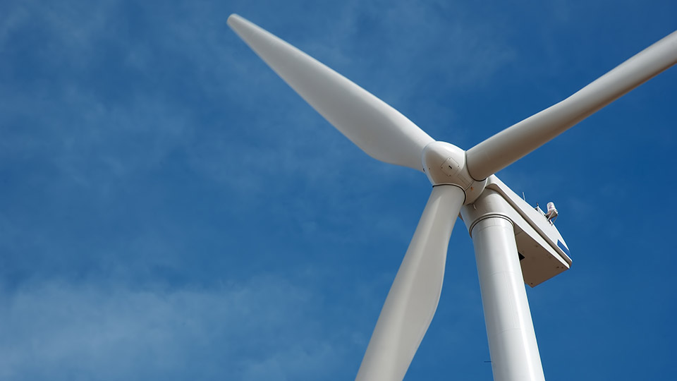Windenergie: Windrad vor blauem Himmel