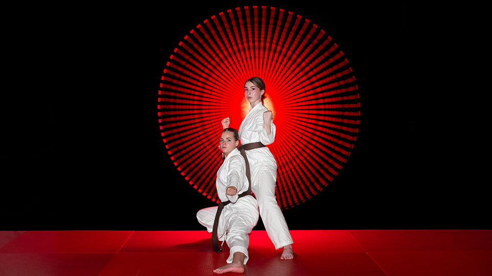 Zwei Mädchen in Kampfposen, die in der Karate-Akademie Regensburg trainiert werden