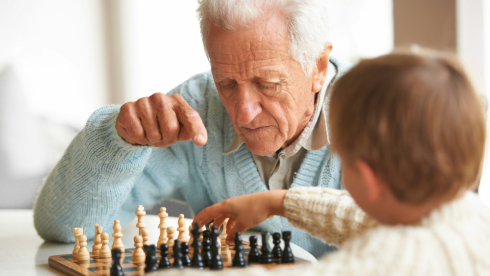Ein Opa spielt mit seinem Enkel Schach