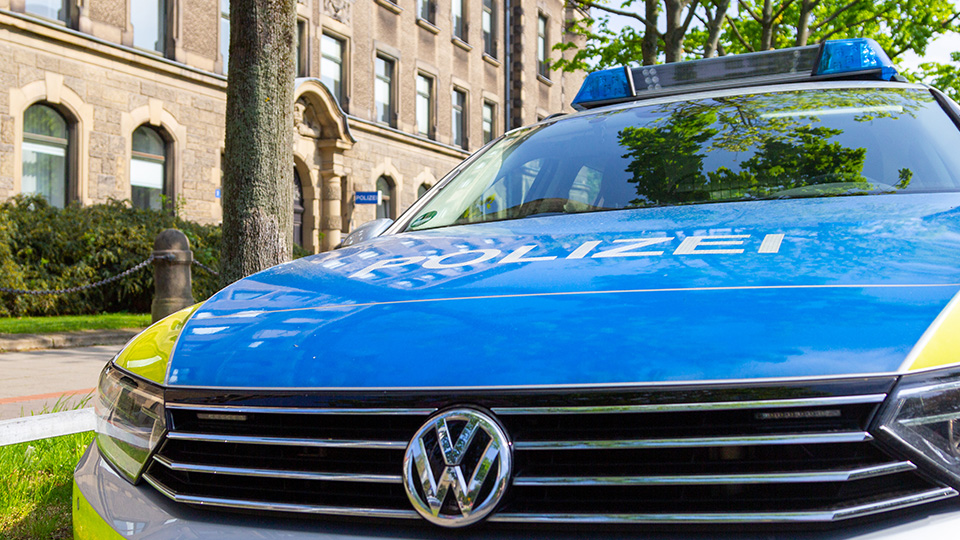 Streifenwagen der Polizei vor Gebäude