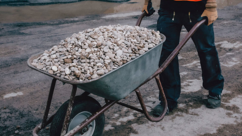 Ein Bauarbeiter mit einer Schubkarre