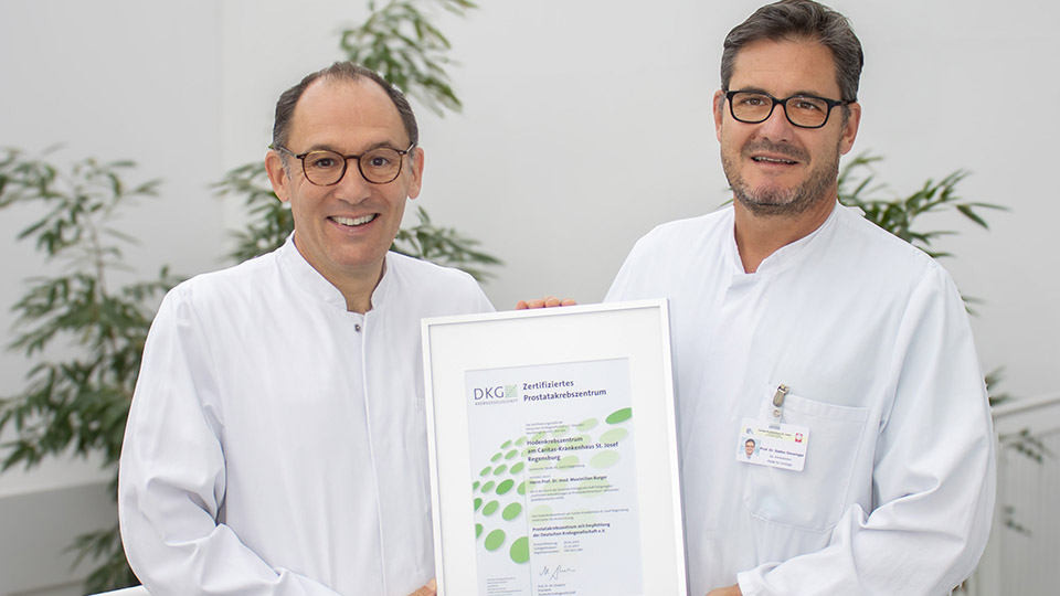 Prof. Burger (l.) und Prof. Denzinger (r.) halten die Auszeichnung stolz in den Händen