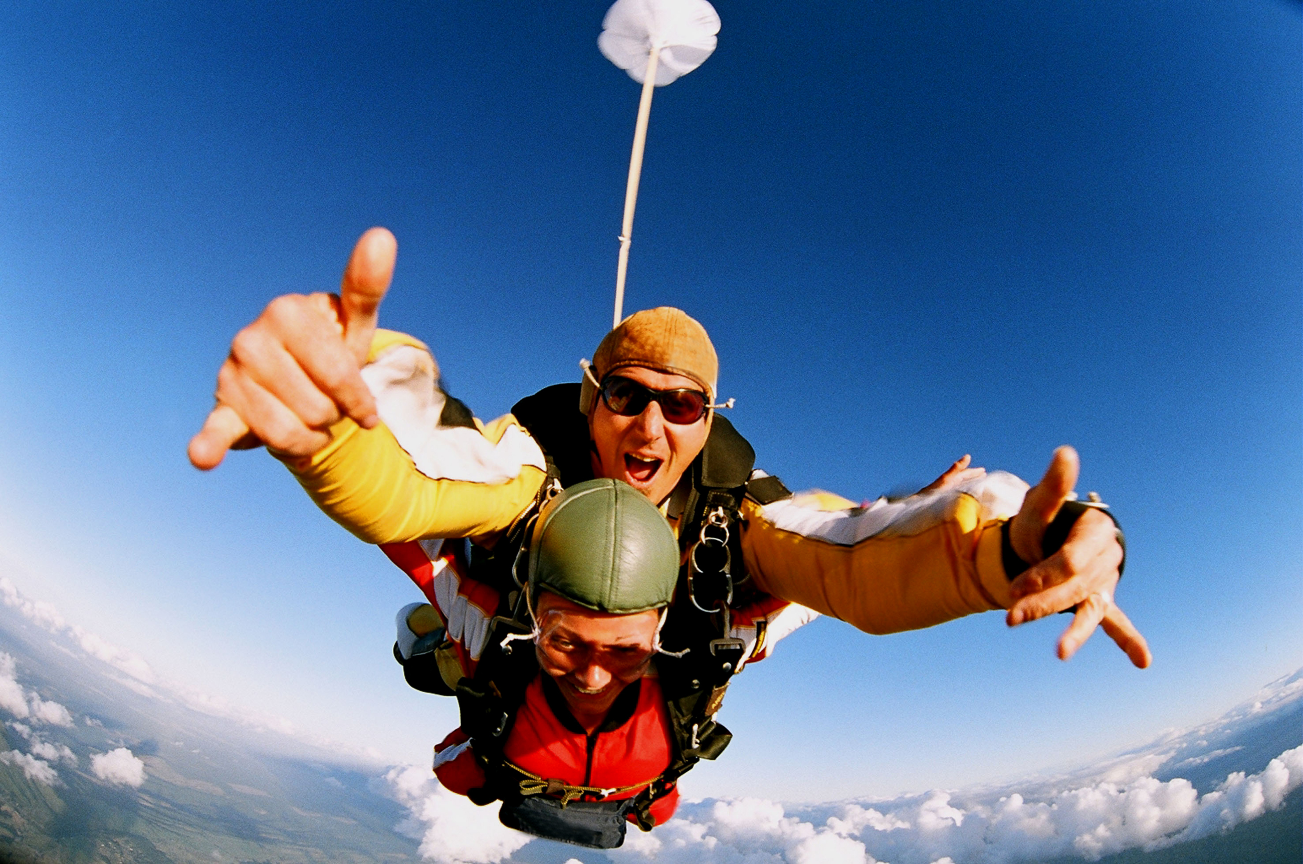 Two people skydiving in tandem from an airplane.