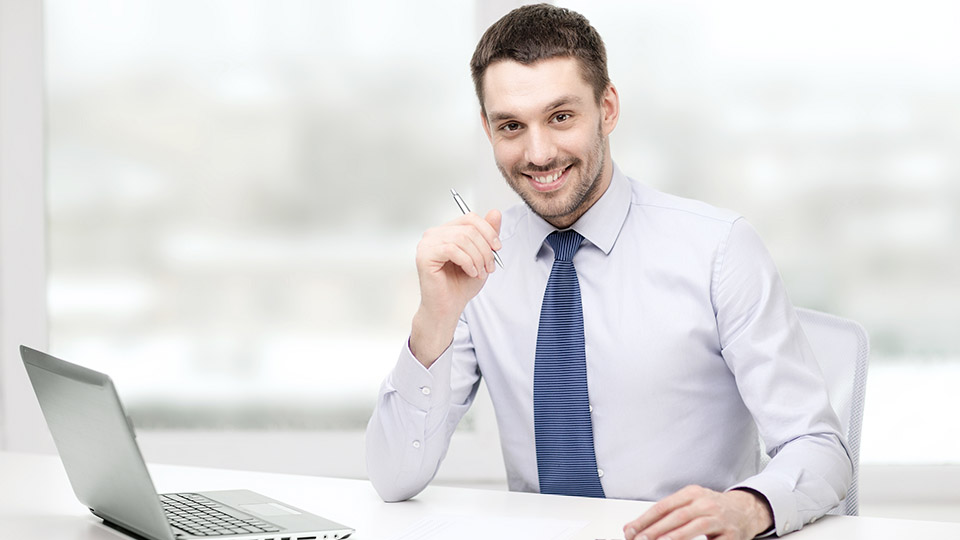 Junger Geschäftsmann im Hemd am Laptop