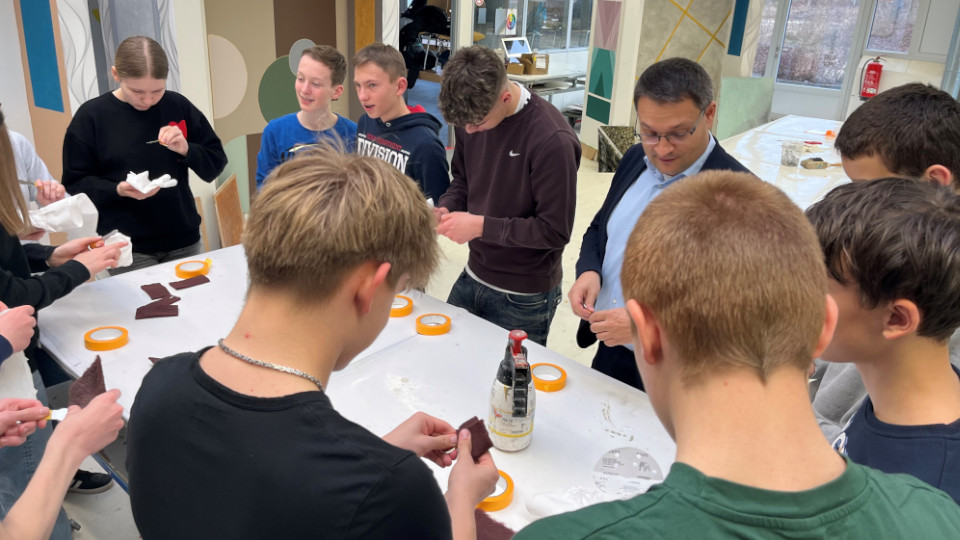 Schülerinnen und Schüler arbeiten handwerklich zusammen