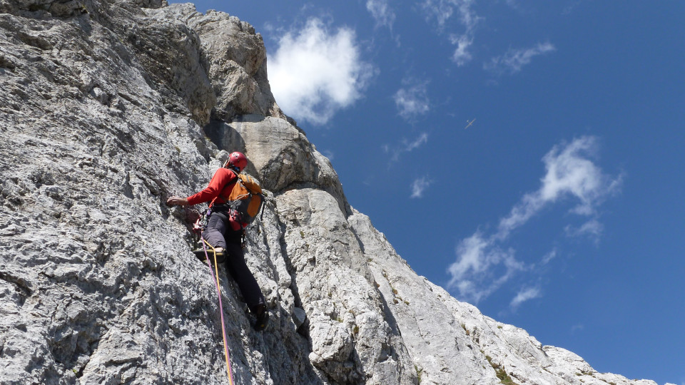 Mann klettert einen Felsen hoch