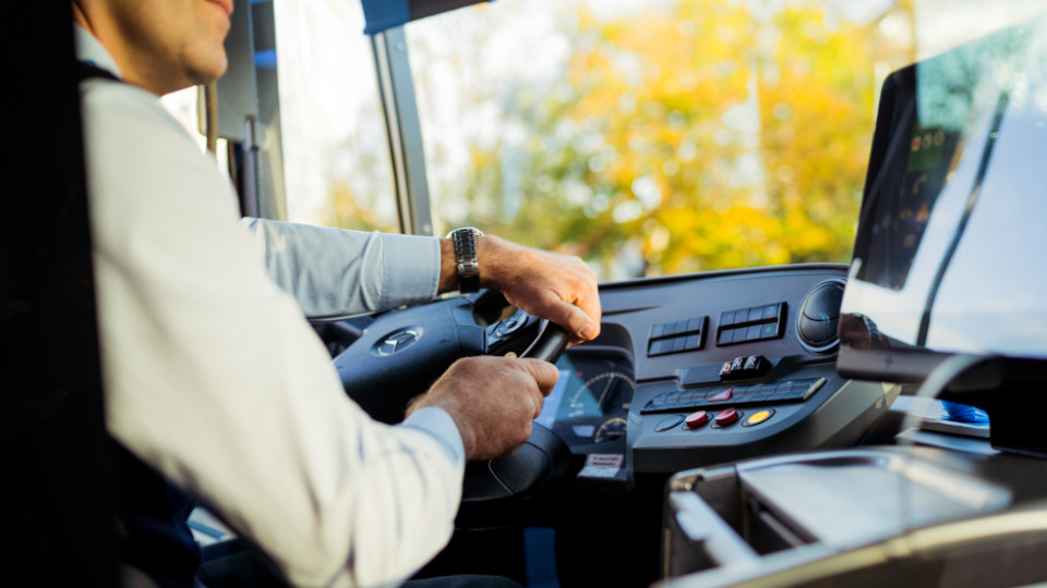 Mann sitzt auf dem Fahrersitz eines Busses