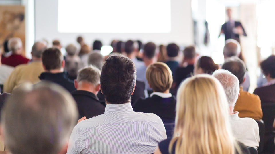 Symbolbild: Menschen sitzen bei einer Infoveranstaltung