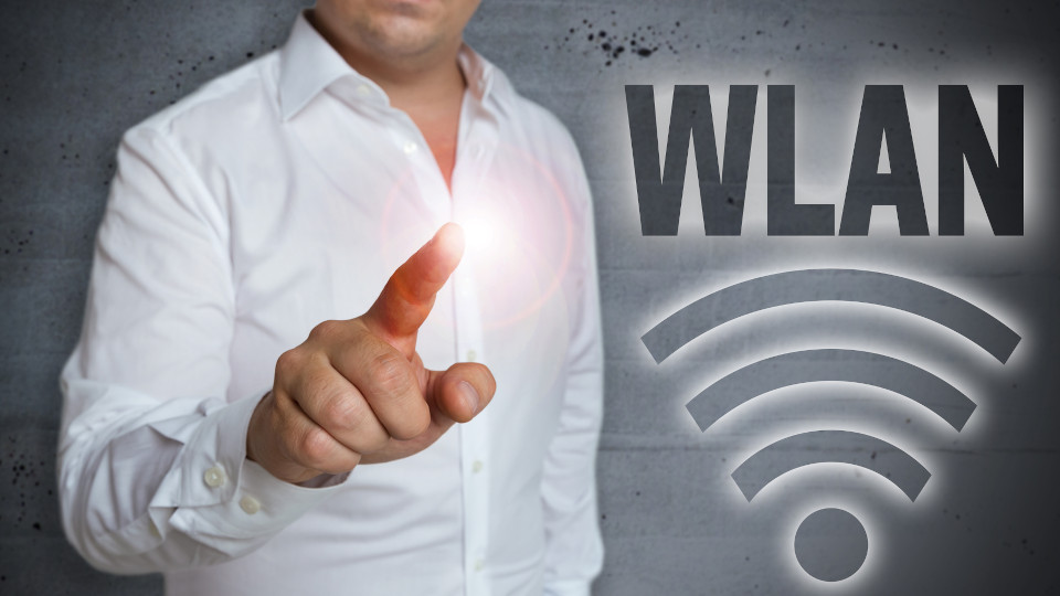 Symbolbild: Mann klickt auf WLAN-Zeichen