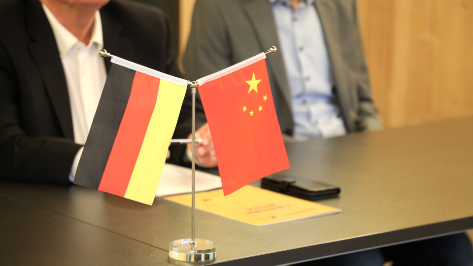 Flaggen von Deutschland und China stehen auf einem Tisch