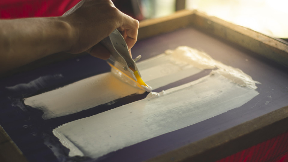 Symbolbild: Mann formt Muster auf T-Shirt