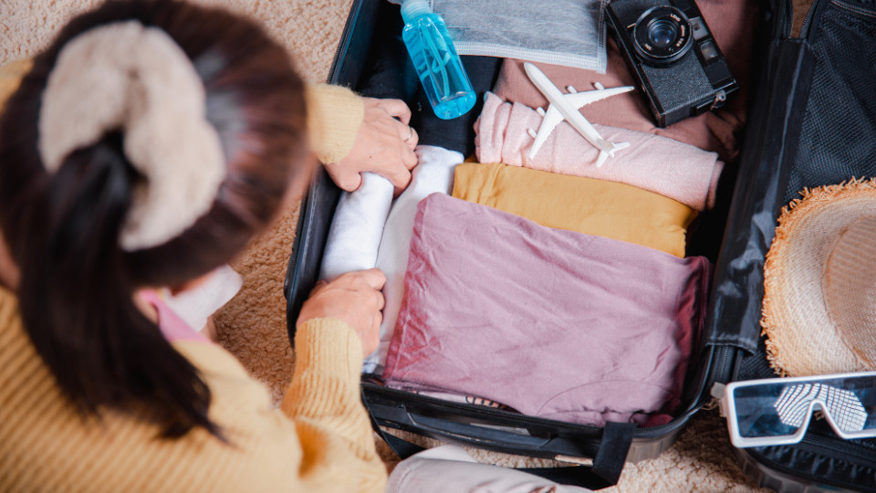 Symbolbild: Frau packt ihren Koffer für den Urlaub