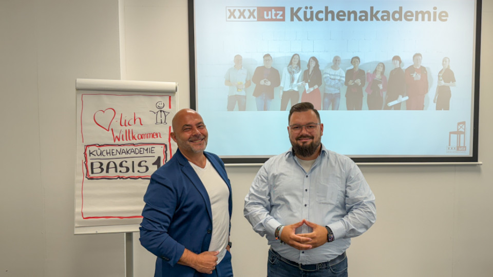 Michele Di Cato (links) und Martin Leitl (rechts) bereiten sich auf die Schulung der Küchenakademie im Schulungsraum in Regensburg vor.