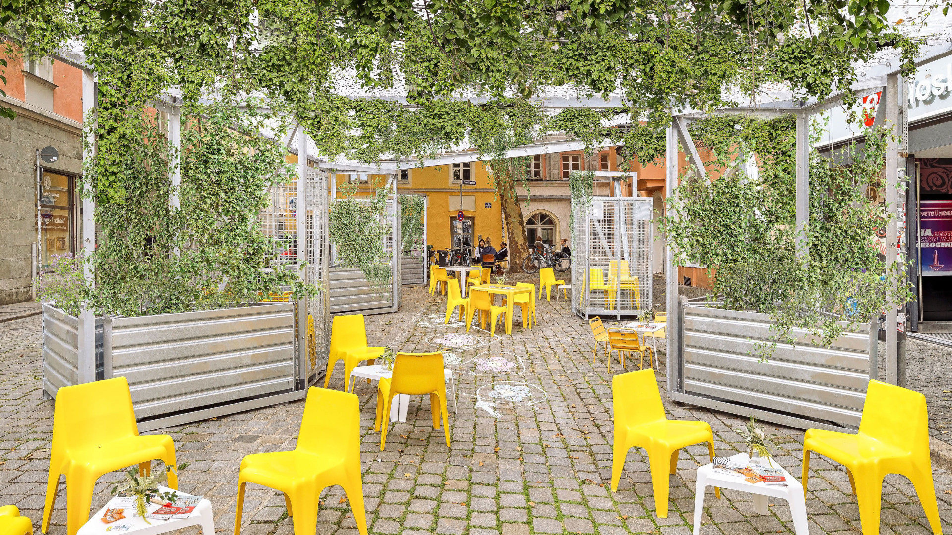 Obermünsterviertel in Regensburg mit grünem Dach und gelben Stühlen