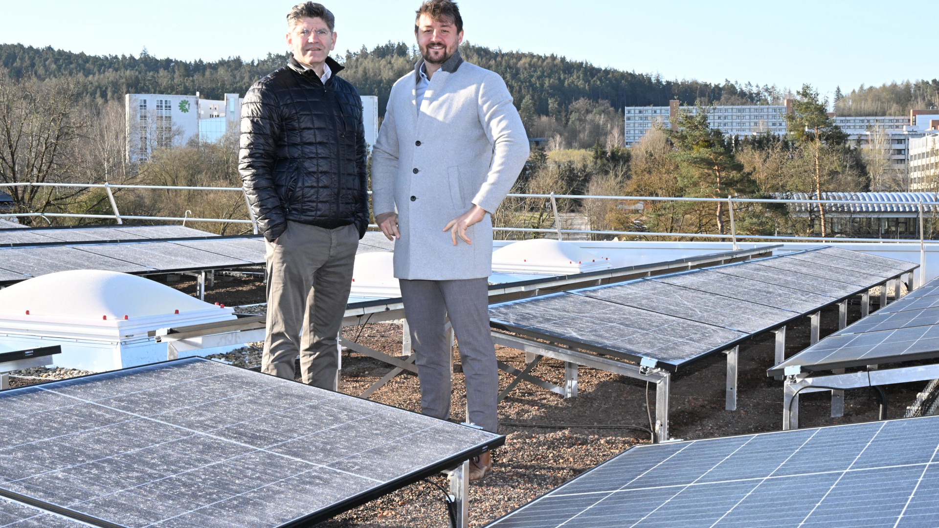 Béla Szabó und Maximilian Köckritz auf dem Dach der Turnhalle der Realschule Regenstauf neben der Photovoltaikanlage
