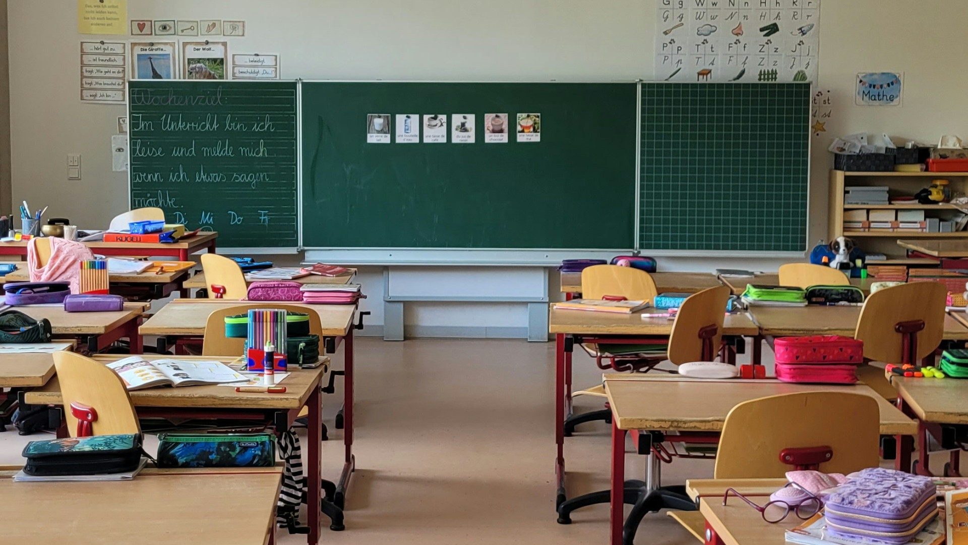 Deutsche zweifeln an Bildungssystem: Klassenzimmer mit aufgeklappter Tafel und leeren Tischen