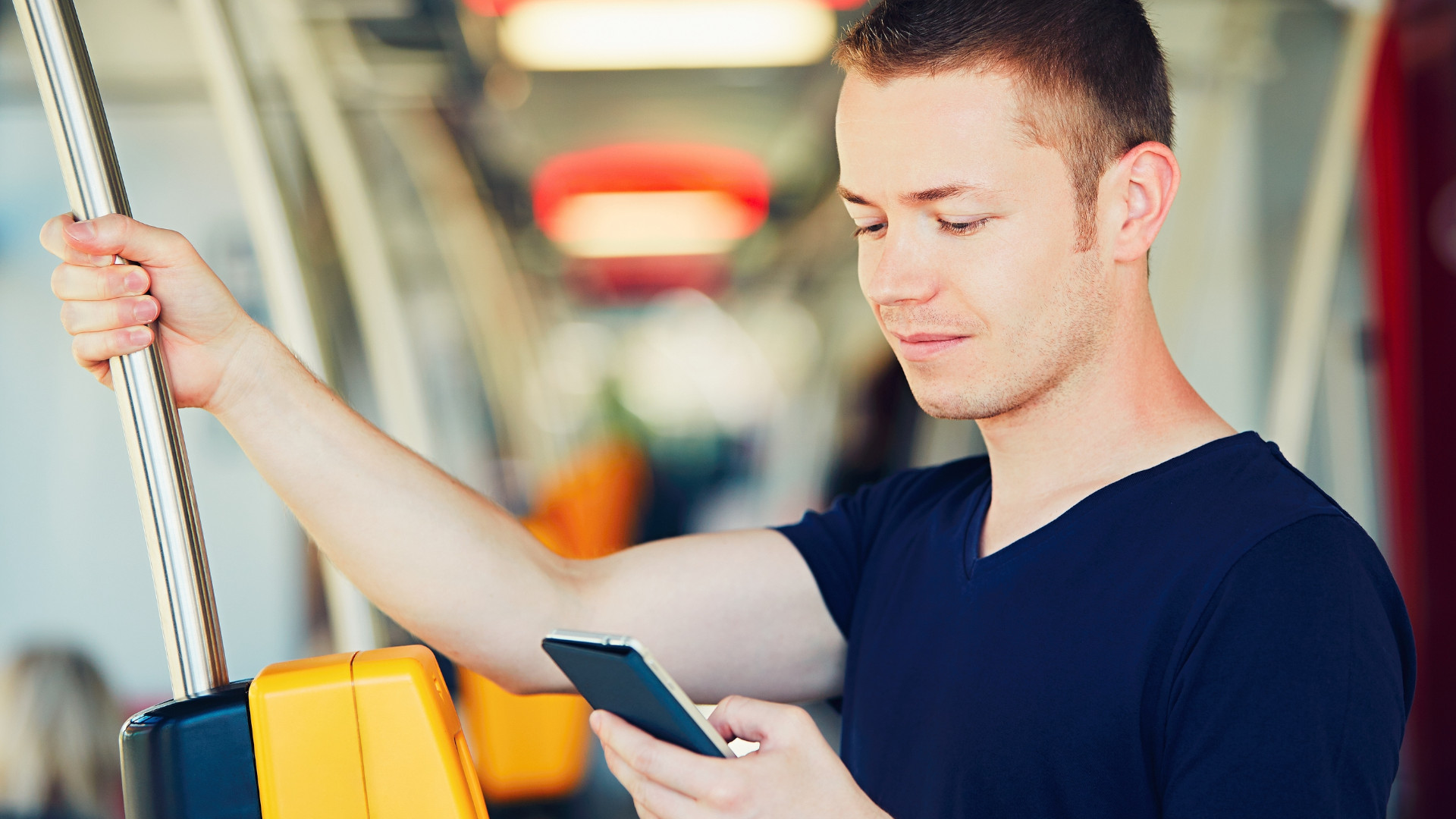 Symbolbild: Junge steht mit seinem Handy im Bus