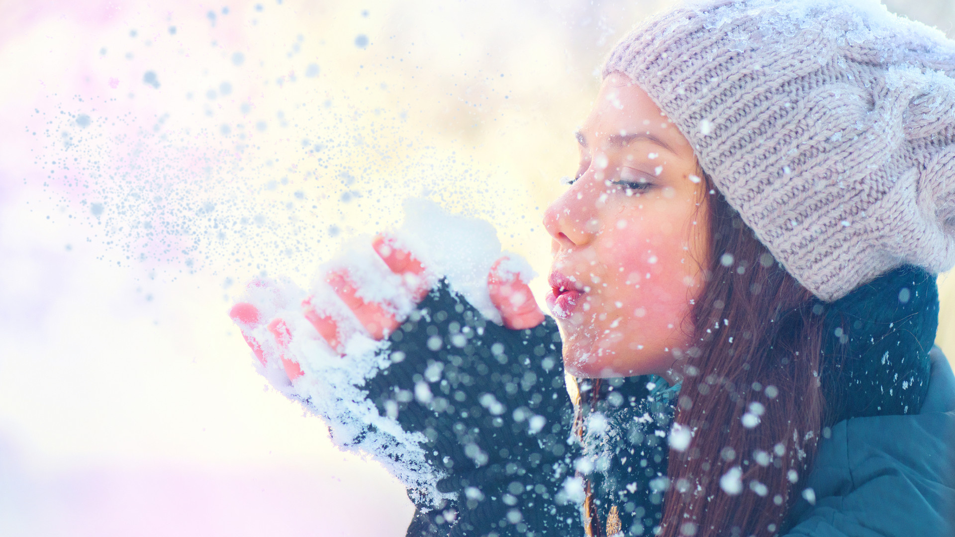 Frau pustet Schnee aus ihrer Hand