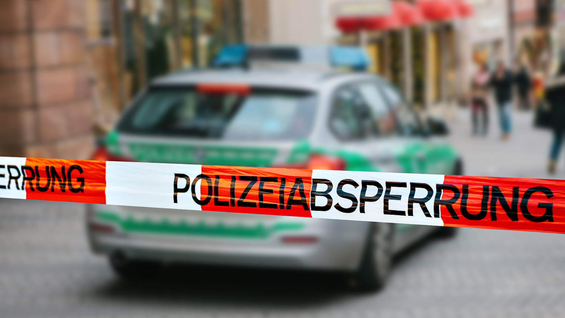 Symbolbild: Polizeiauto mit Absperrband