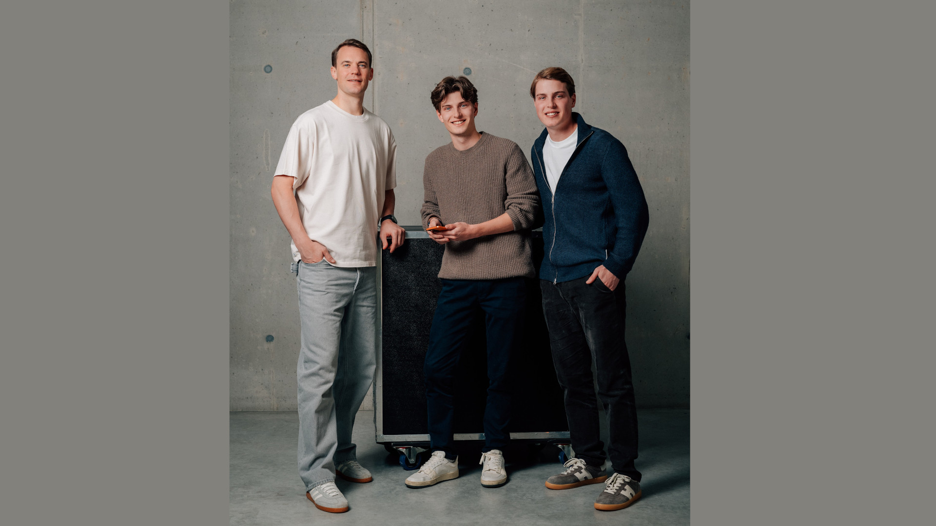 Fußballweltmeister und Familienvater Manuel Neuer (links) unterstützt das Gründerteam Moritz (Mitte) und Jannis Hutzler von Kidgonet, die mit ihrer App mehr Sicherheit für Kinder im digitalen Raum schaffen.