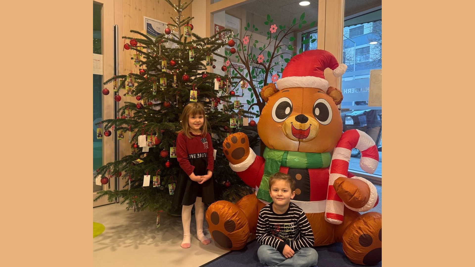 Kinder sitzen vor dem Weihnachtsbaum
