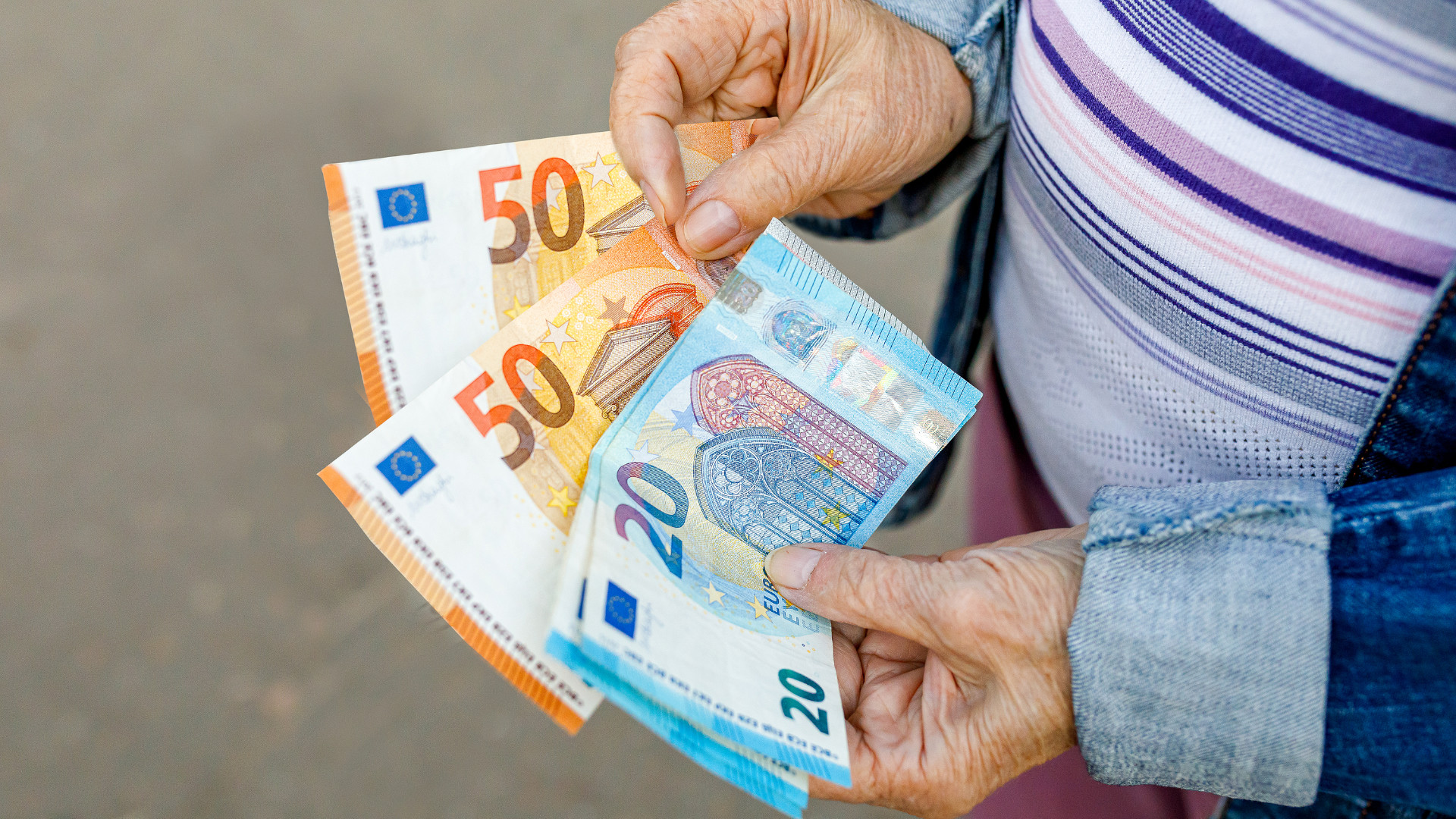 Symbolbild: Seniorin hält Geld in den Händen