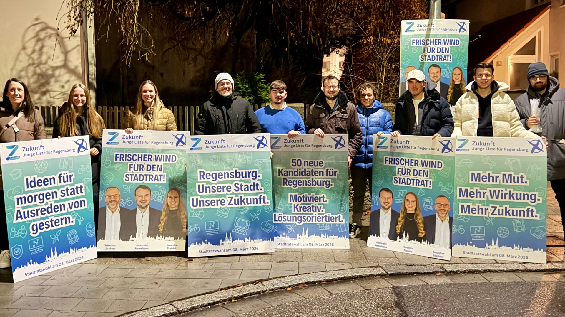 Gruppenfoto der Partei mit Wahlplakaten