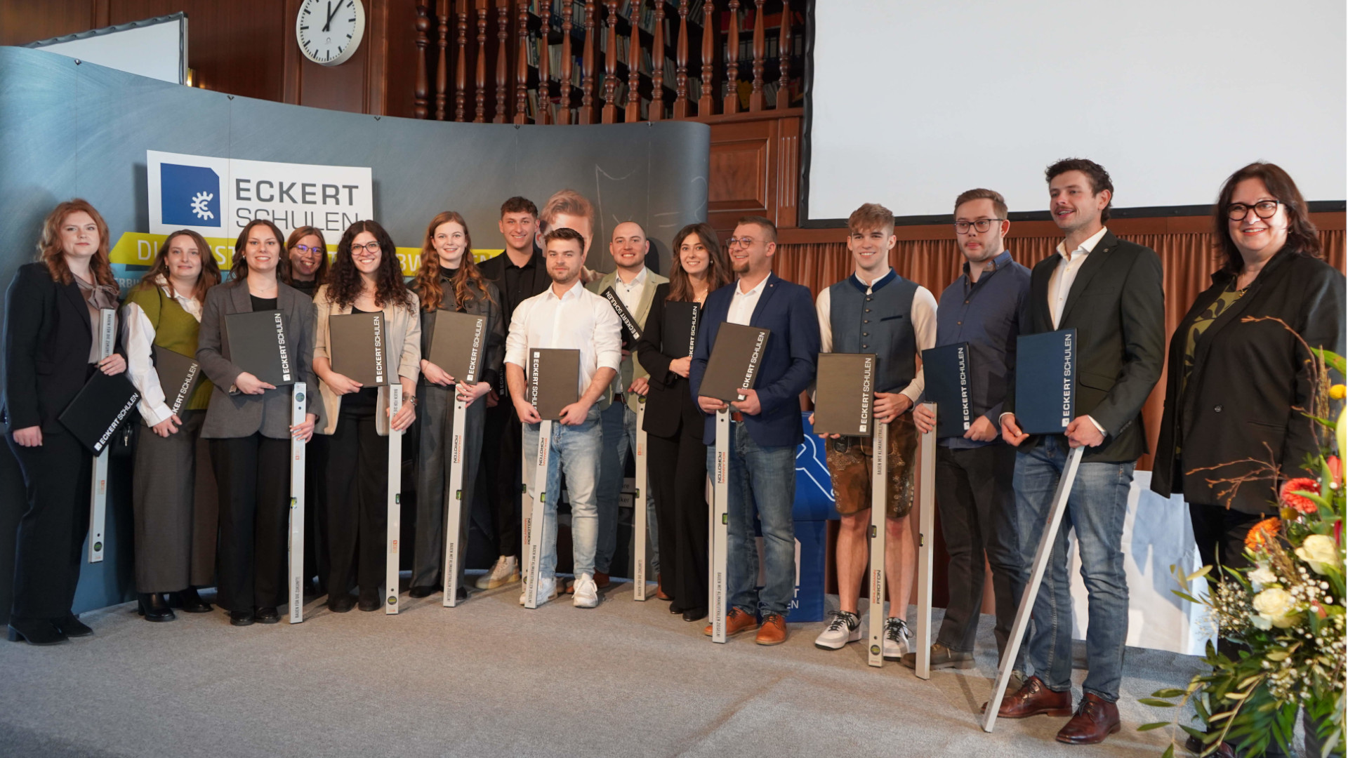 Absolventinnen und Absolventen mit ihren Abschlüssen in den Händen 