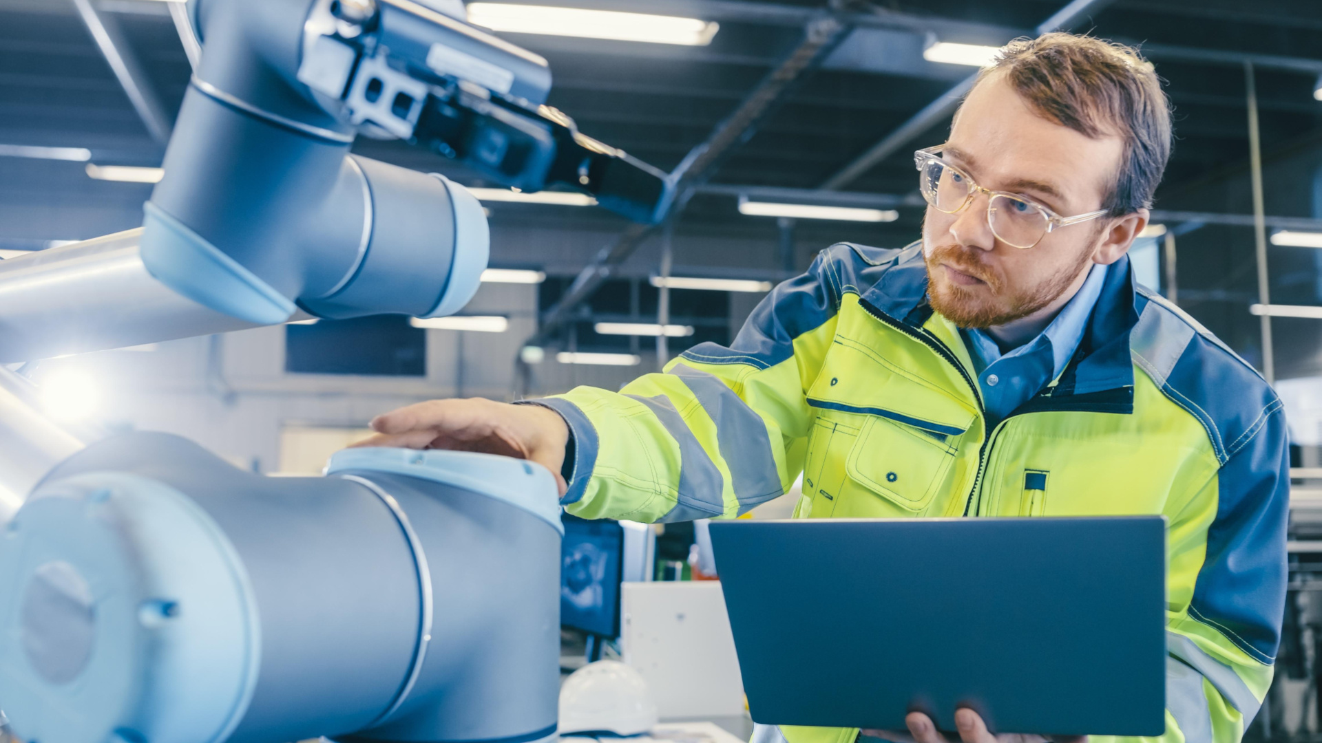 Mann neben Maschine am Computer
