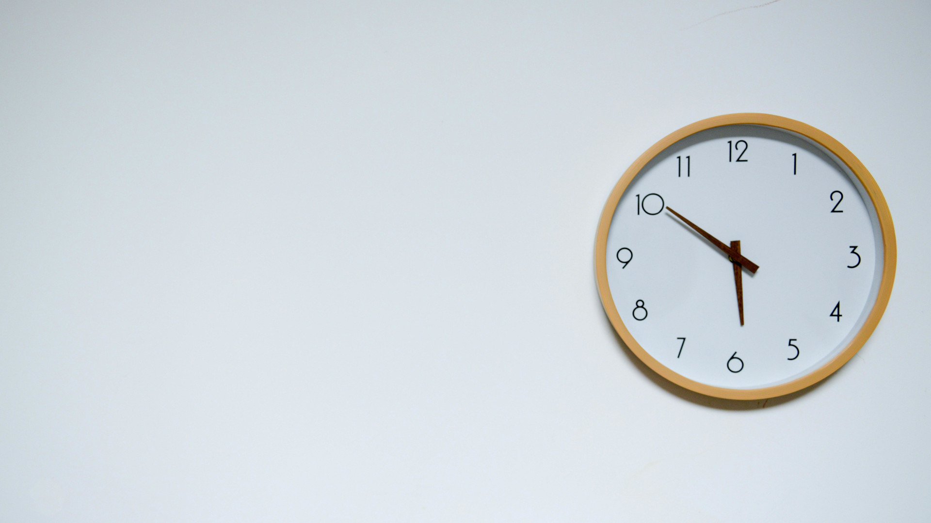 Symbolbild: Uhr hängt an der Wand