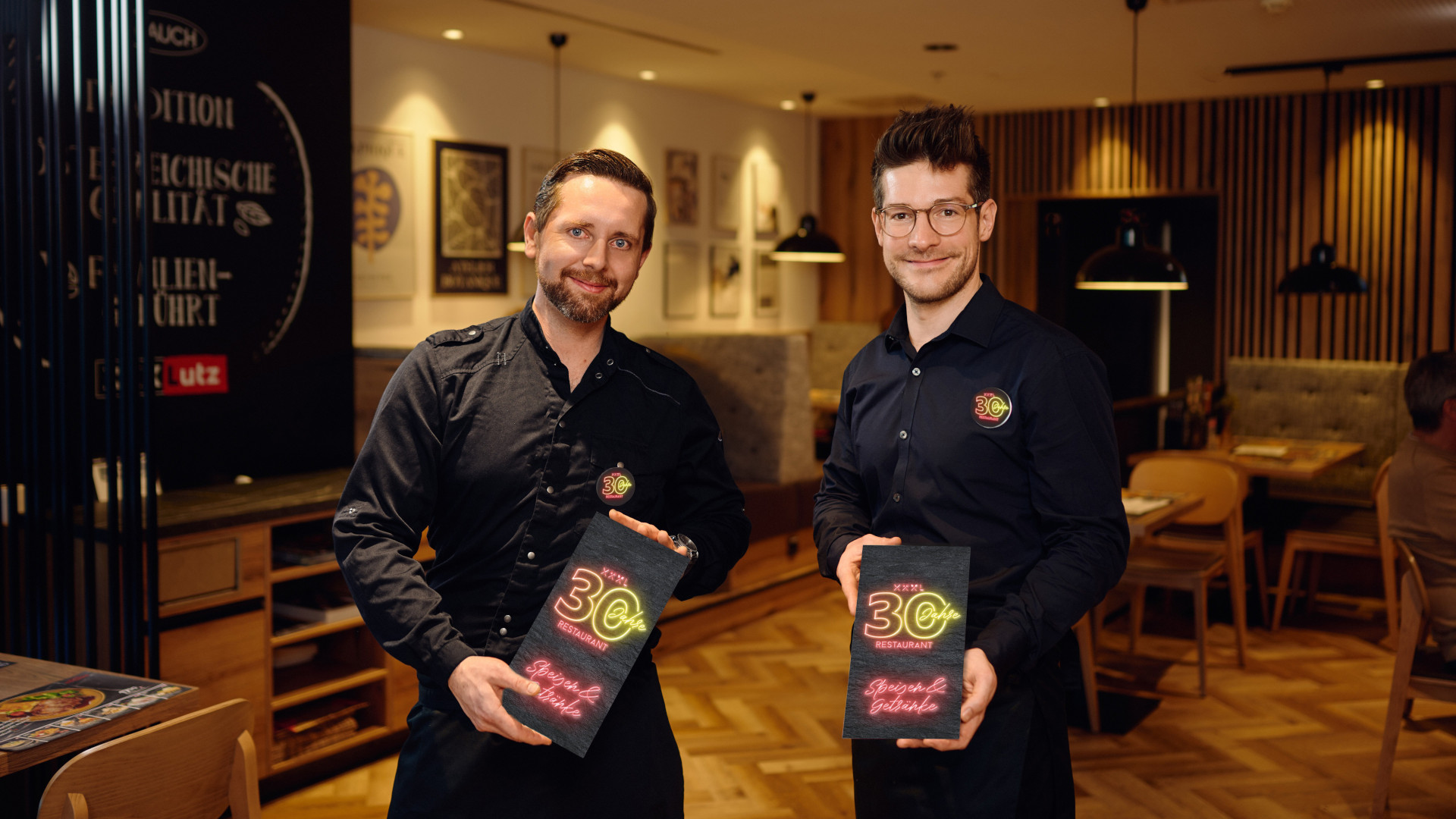 Zwei Köche stehen im XXXLutz und bewerben das 30-jährige Jubiläum