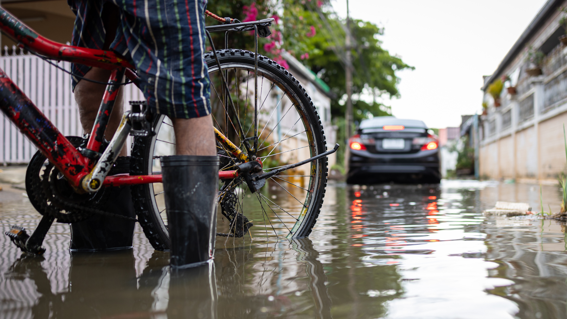 Radfahrer und Auto im Hochwasser