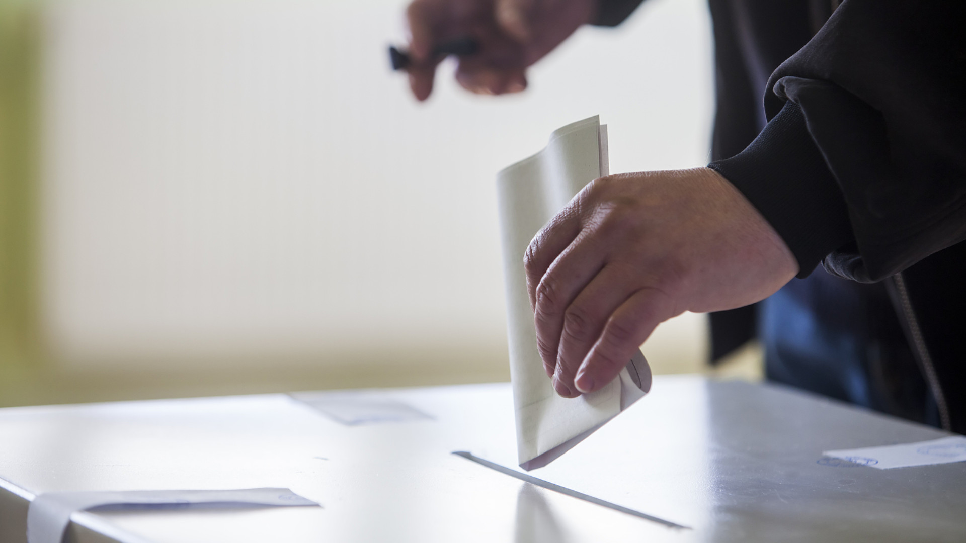 Symbolbild: Mann wirft Zettel in Wahlbox
