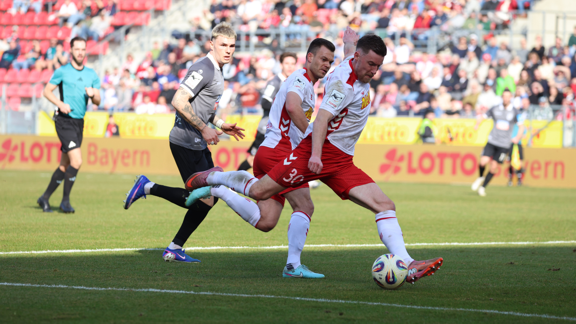 Spieler des Jahn liefern sich Rennen um de Ball