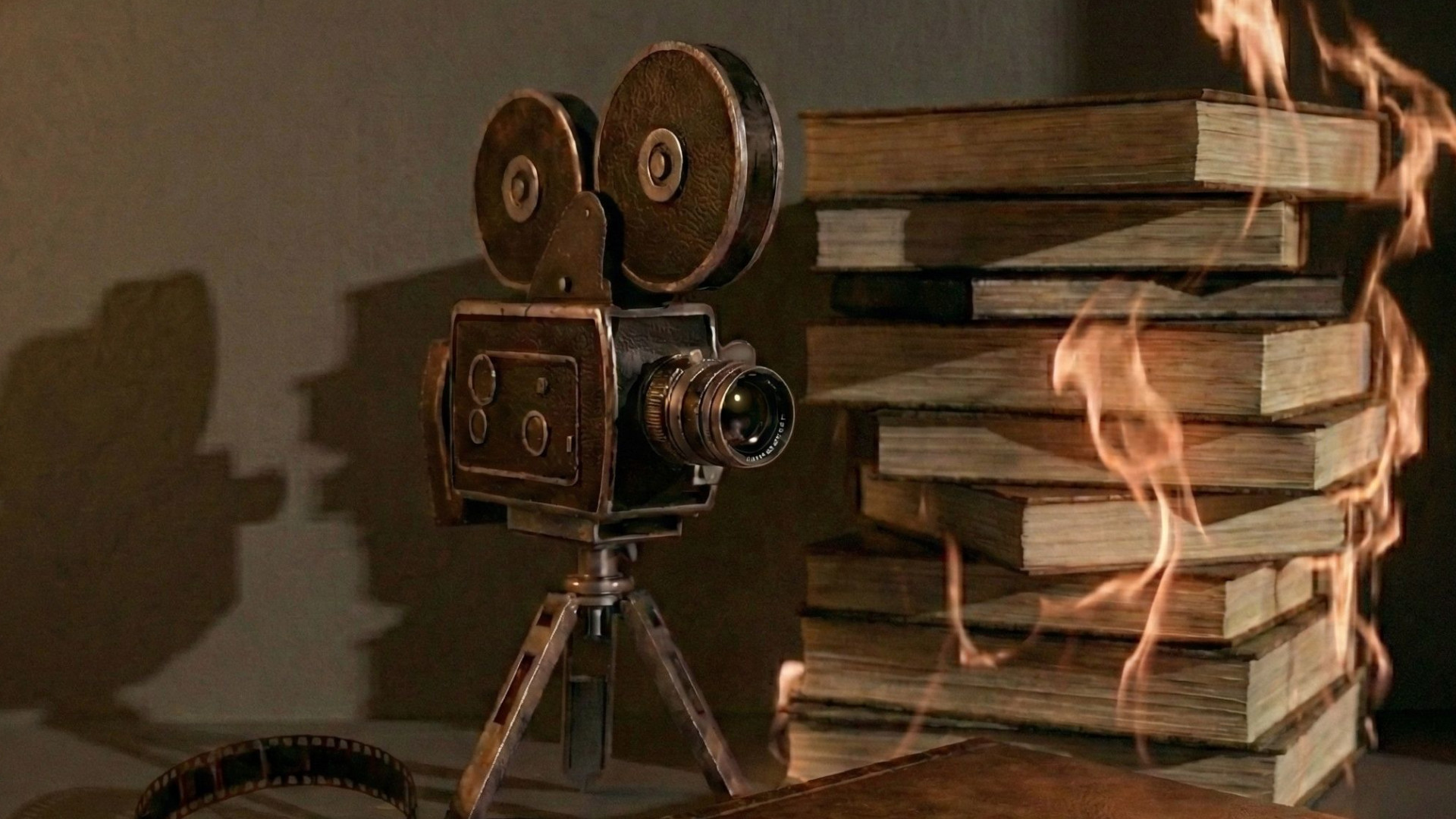 Symbolbild: Kamera steht neben brennenden Büchern