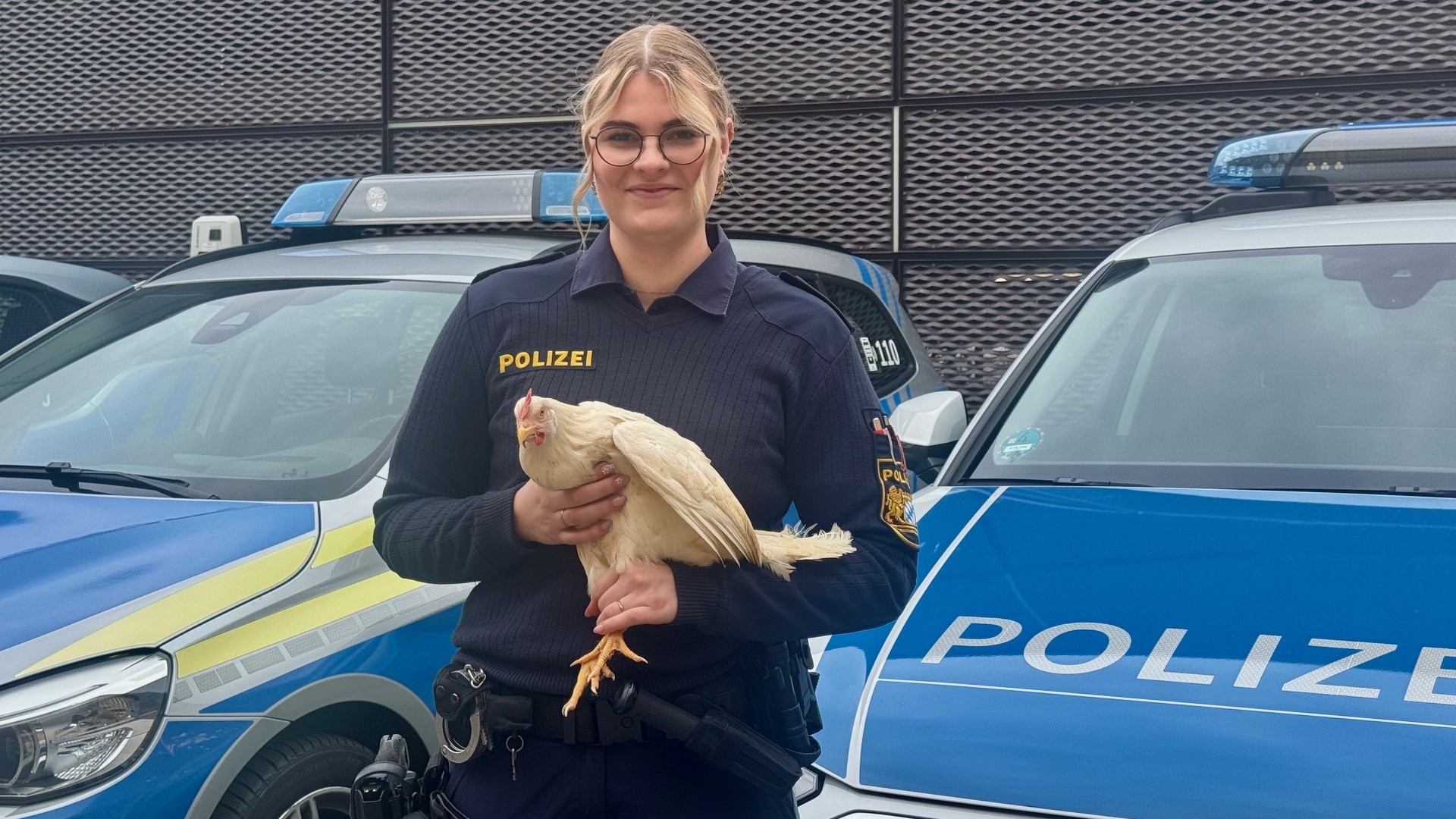 Polizistin hält Huhn