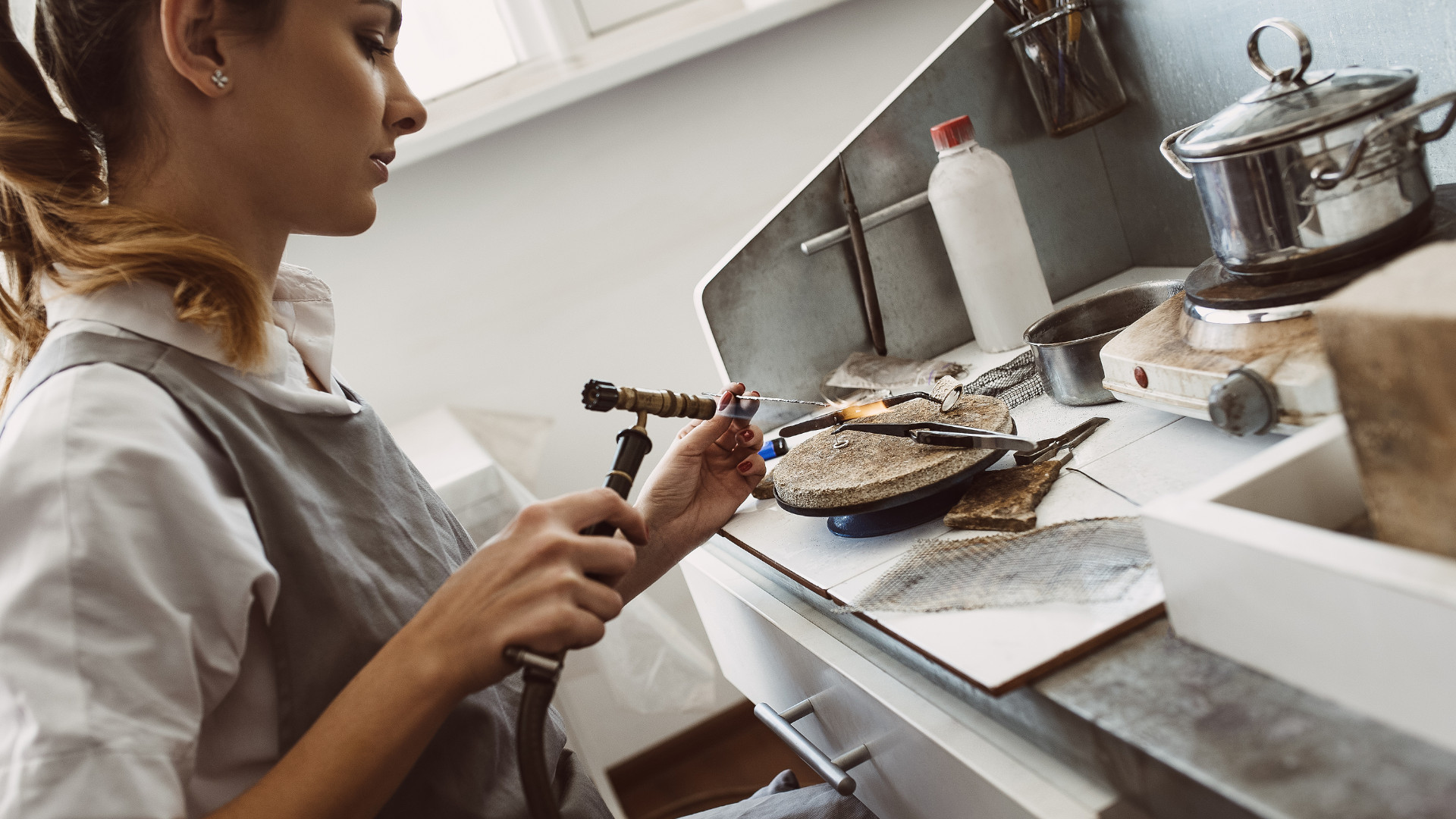 Symbolbild: Frau lötet Ohrringe