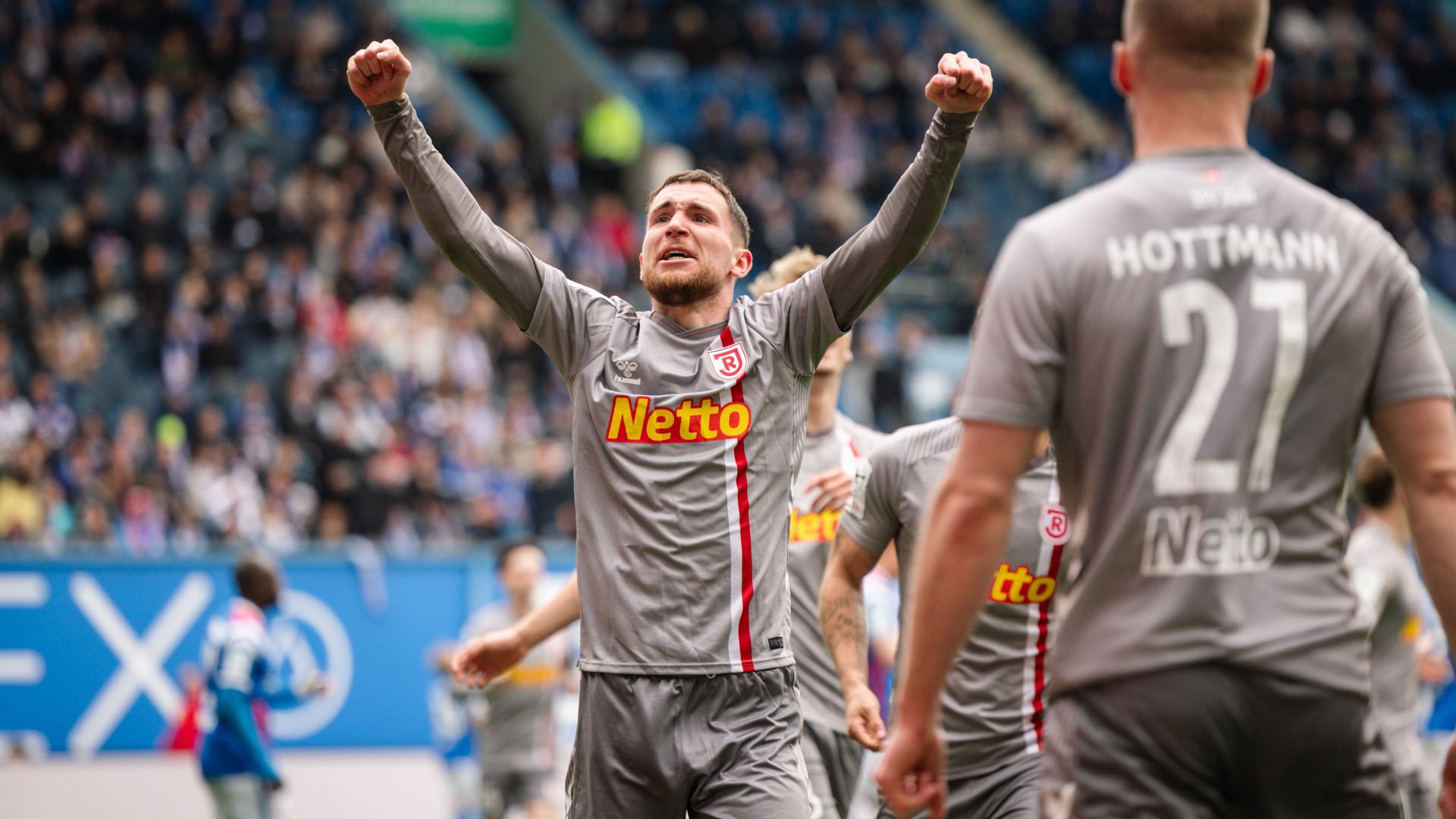 Fußballspieler streckt die Arme in die Luft und jubelt über den Sieg