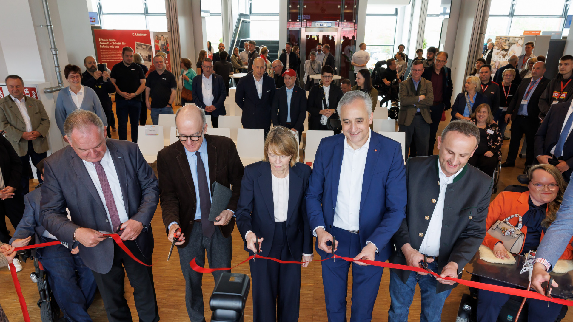Elke Büdenbender und OB Thomas Burger (Mitte) eröffneten gemeinsam mit dem Kelheimer Landrat Christian Nerb (links) und dem stellvertretendem Regensburger Landrat Josef Schütz (rechts) sowie Amtschef Dr. Markus Gruber vom Bayerischen Sozialministerium sowie weiteren Ehrengästen mit einer symbolischen Durchtrennung eines roten Bandes die dritte Inklusive Jobmesse im Regensburger Jahnstadion.