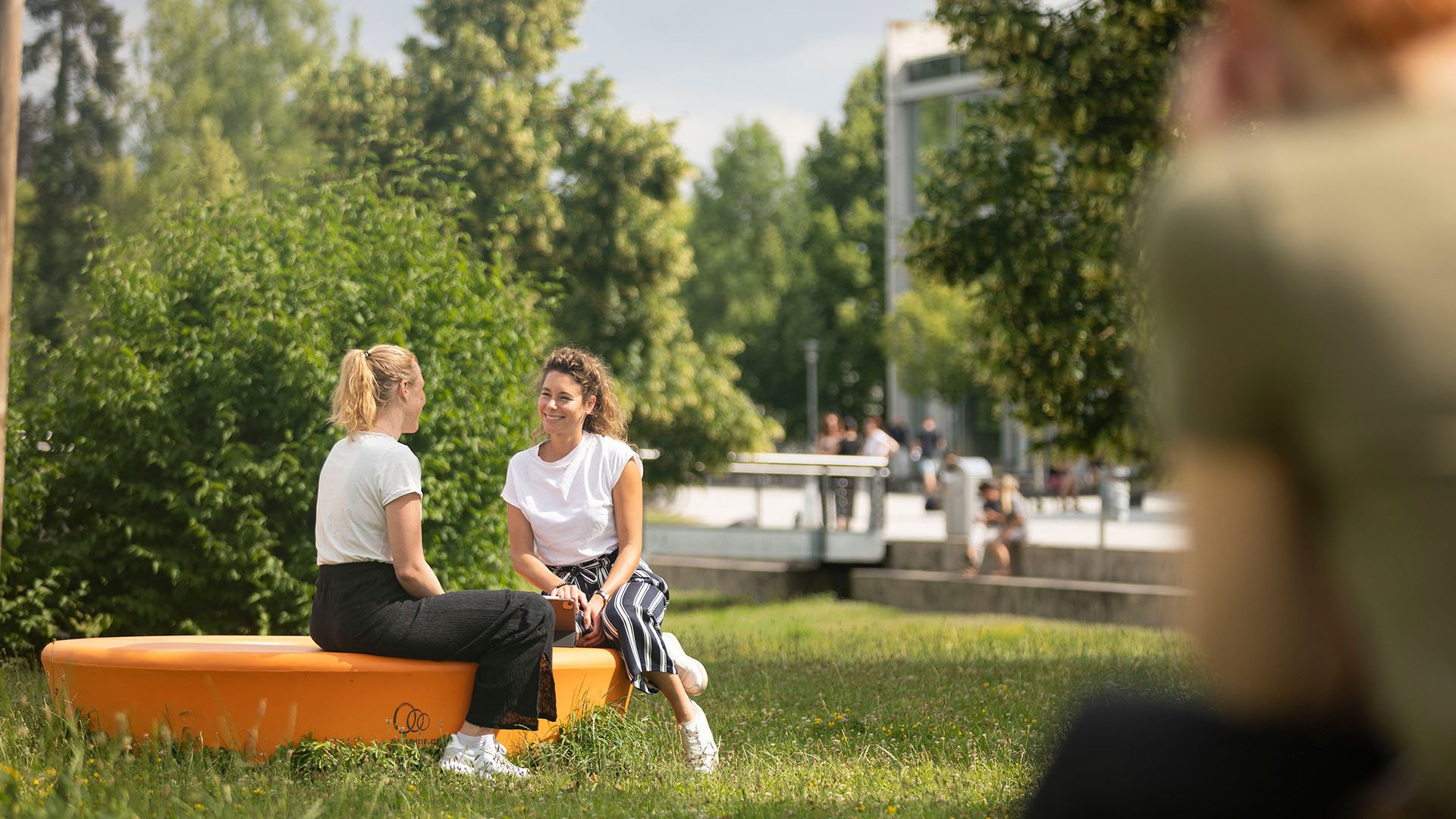 Zwei Frauen sitzen am Campus der OTH und unterhalten sich