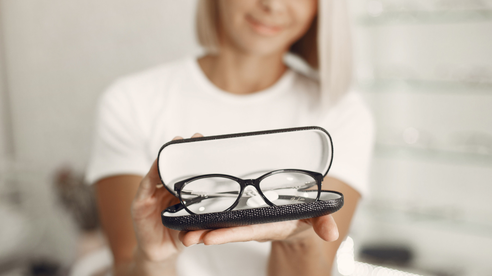 Dame hält eine Brille in die Kamera
