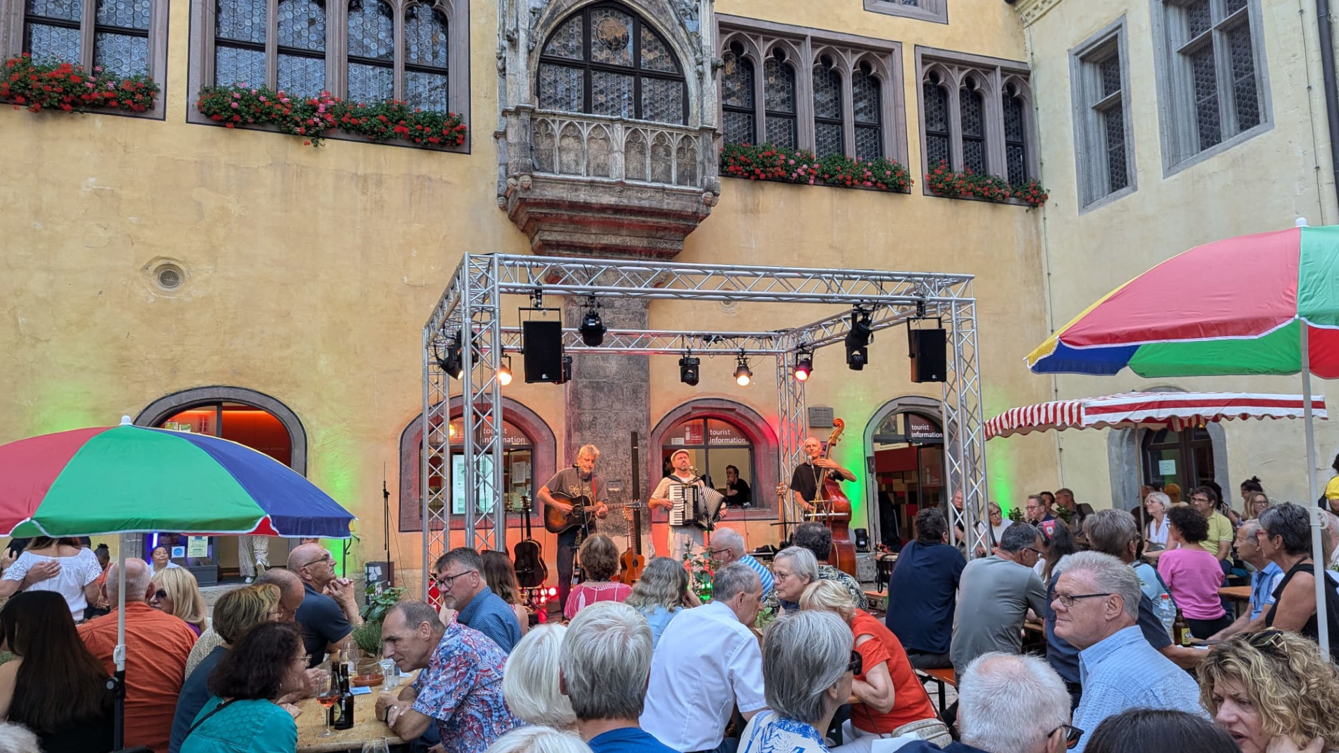 Lange Nacht der Tourist Information: Impressionen eines zurückliegenden Fests mit Bühne und bunten Sonnenschirmen