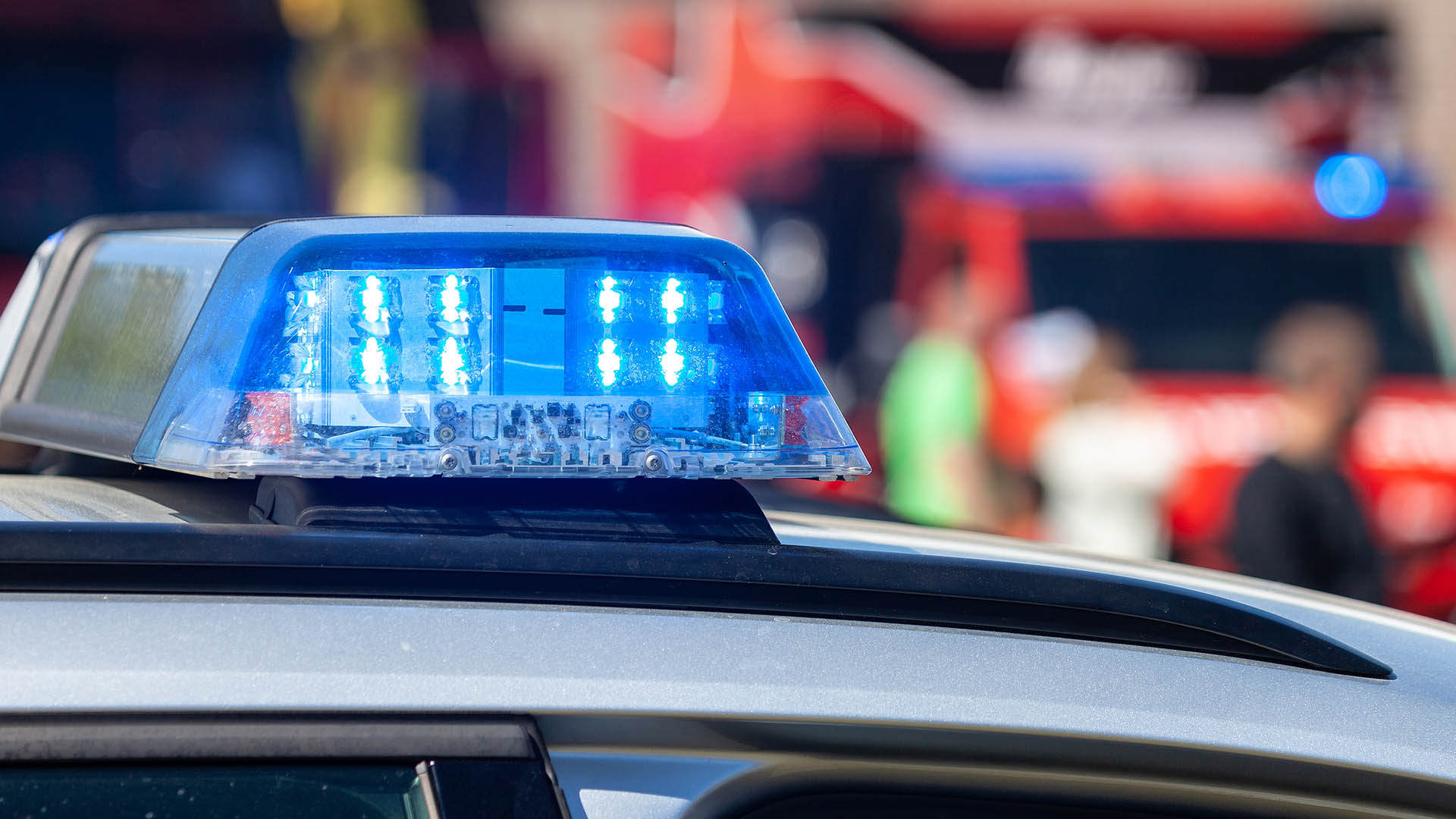 Streifenwagen der Polizei mit Blaulicht und Krankenwagen im Hintergrund