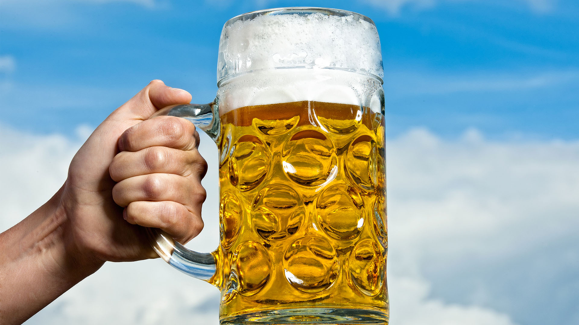Bierkrug, den jemand in die Höhe hält