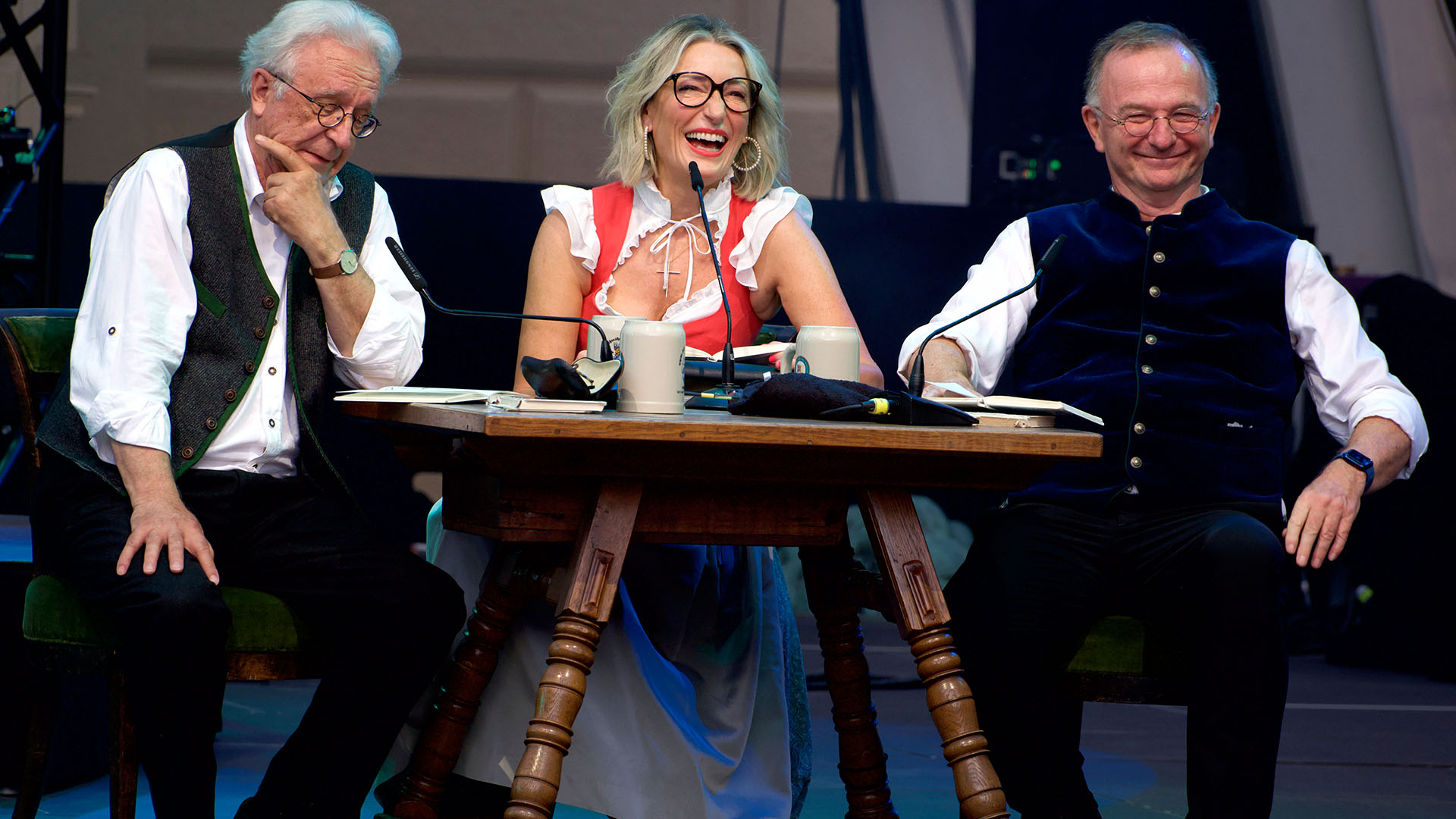 Gerd Anthoff (li), Monika Gruber (m) und Michael Lerchenberg (re) sitzen am Tisch beim Interview