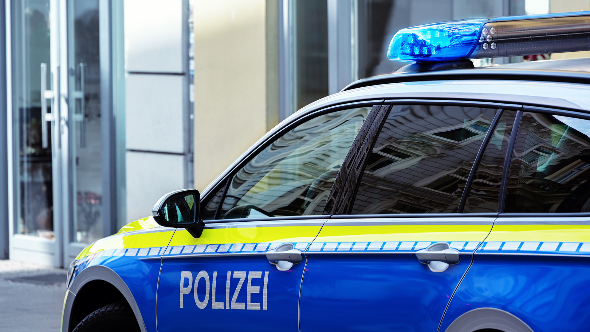 Streifenwagen der Polizei vor Gebäude